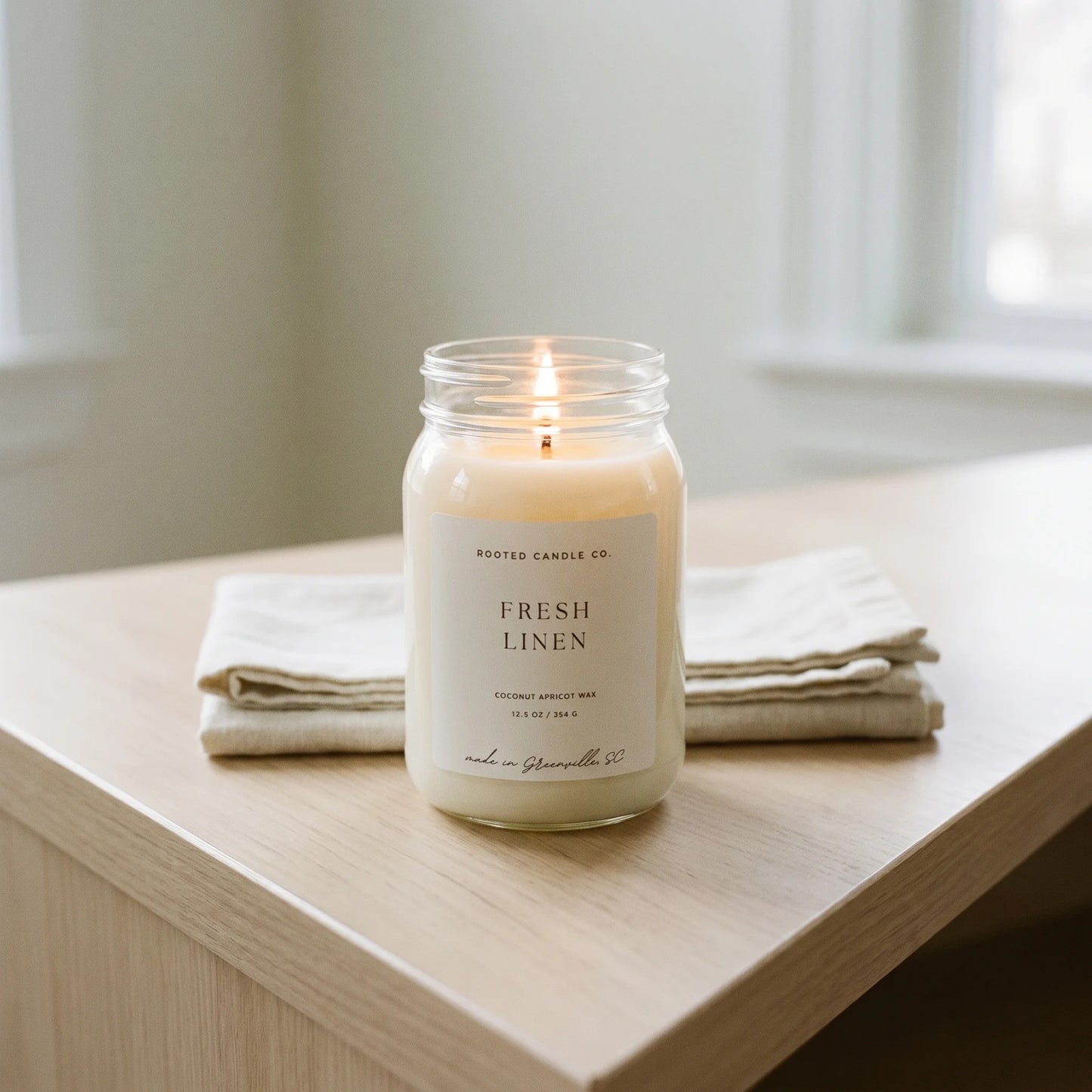 Fresh Linen candle on console with folded linen napkins