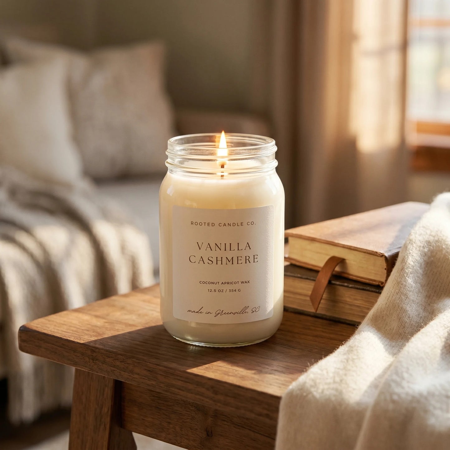Vanilla Cashmere candle on walnut console with leather books and cashmere scarf
